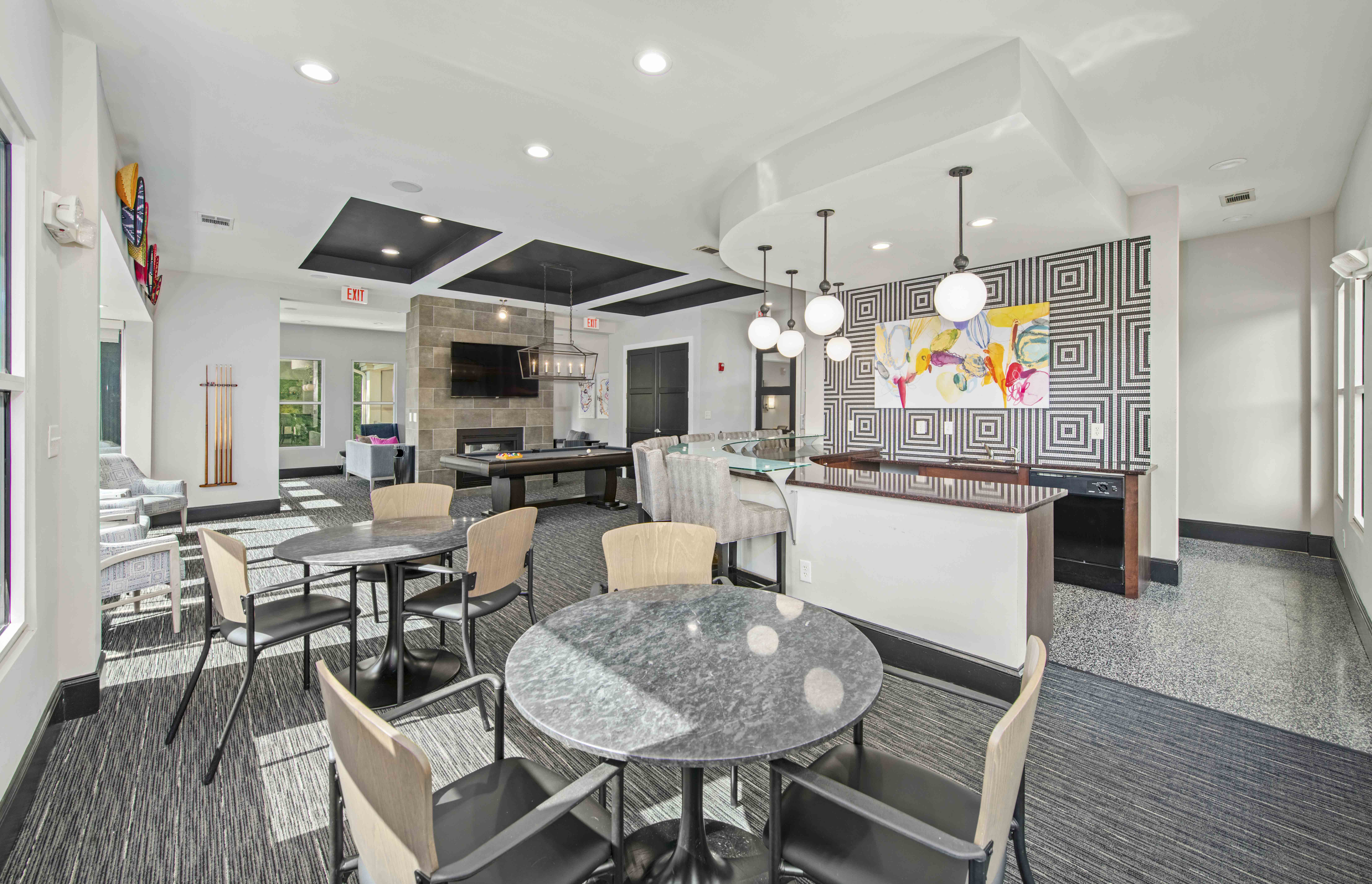 a dining room with tables and chairs and a kitchen